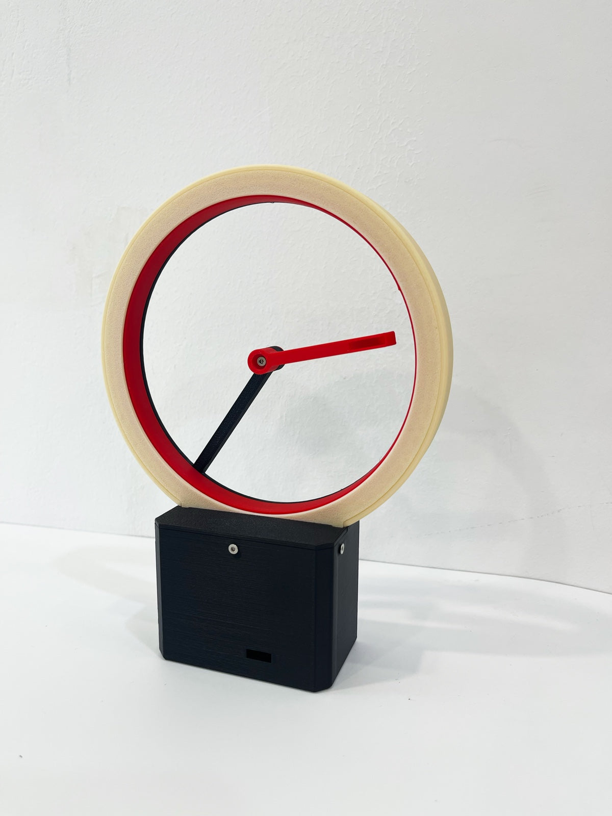 Kickback Clock — matte bone white hollow ring clock with red hands, front view